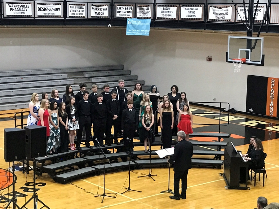 people wearing formal attire standing in risers